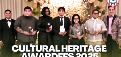 Group photo of the 2025 TEACH Cultural Heritage Awardees standing on a decorated stage, each holding an award trophy, with a warm floral and illuminated backdrop and the IAM FAME INC. logo displayed.