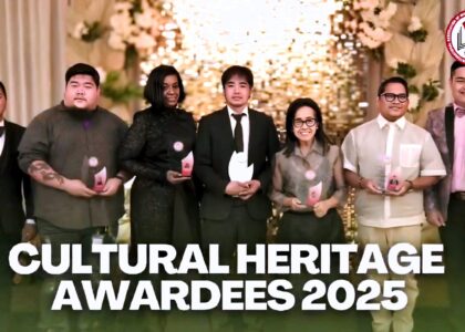 Group photo of the 2025 TEACH Cultural Heritage Awardees standing on a decorated stage, each holding an award trophy, with a warm floral and illuminated backdrop and the IAM FAME INC. logo displayed.